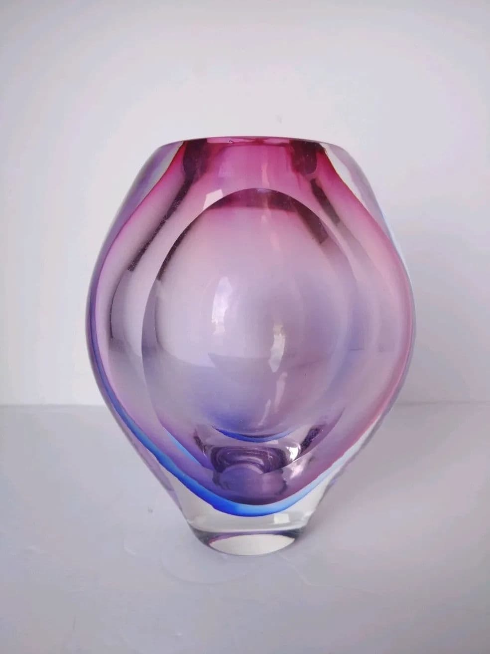 Colorful glass vase with a swirling design in pink and purple tones.